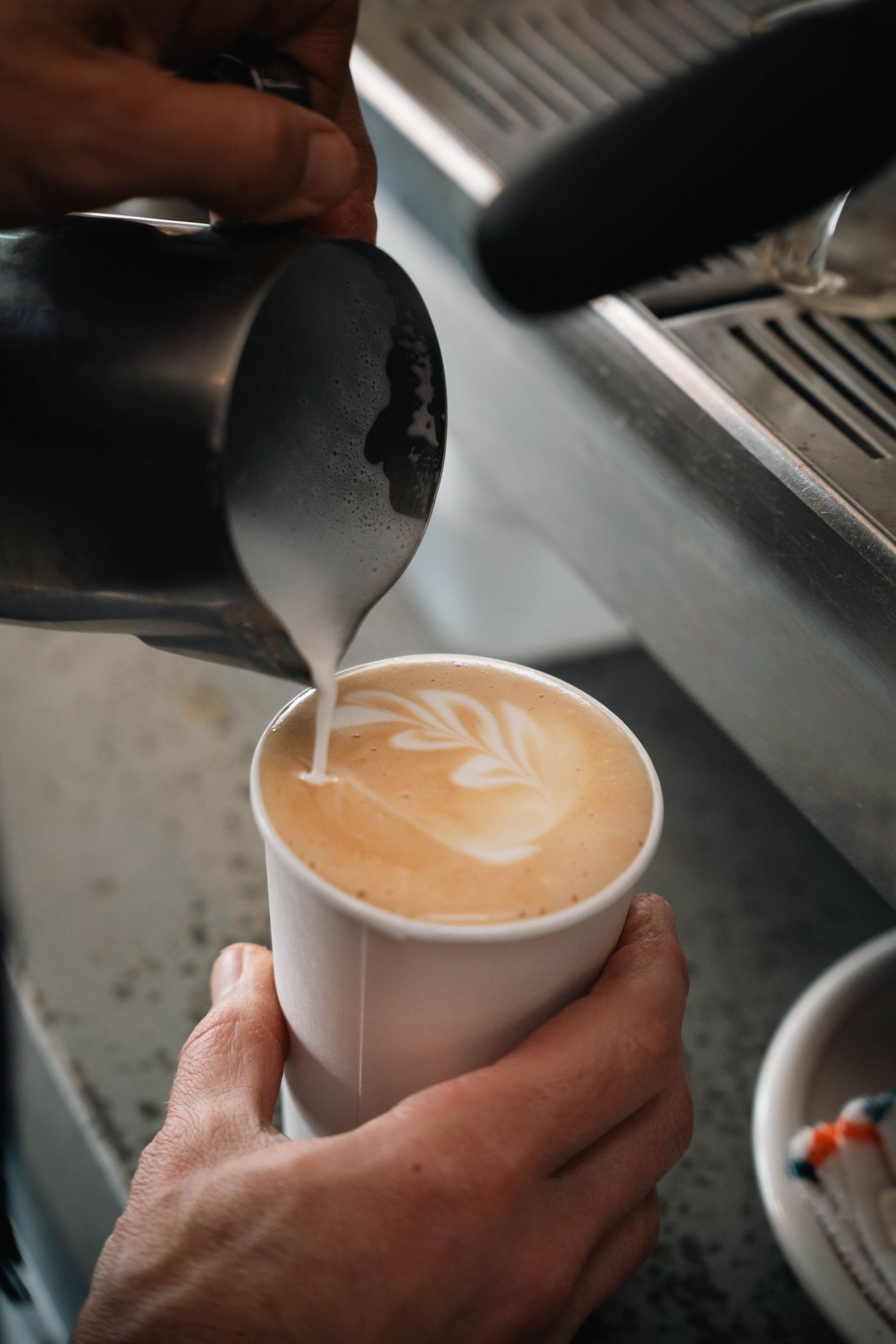 Barista crafting latte art inside the Wagon